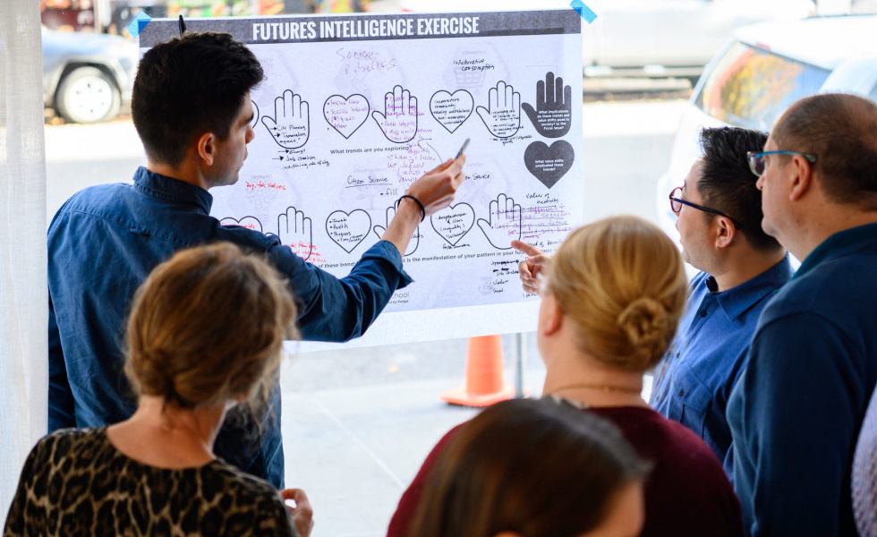 Professionals standing around a chart collaboratiing