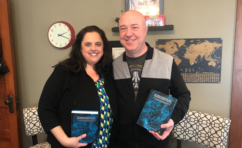 Yvette and Frank hold a textbook that they are published in